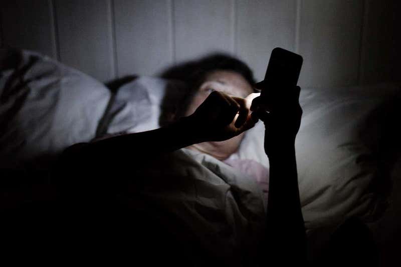 Slaapgebrek man met smartphone in bed 1