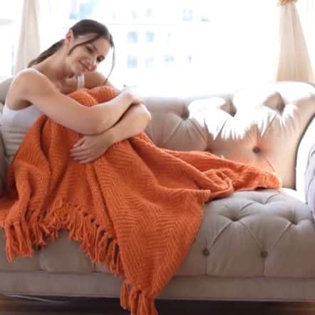 vrouw op de bank met een oranje deken uniek