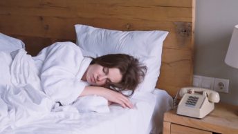 vrouw slaapt op bed telefoon op nachtkastje uniek