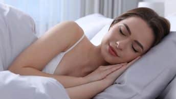 vrouw slaapt op beide handen, grijs satijnen kussen en deken uniek